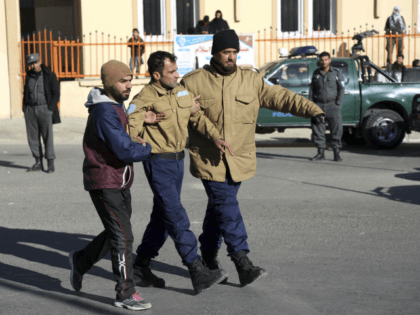 Afghan security personnel escort a man rescued from the Intercontinental Hotel after an at