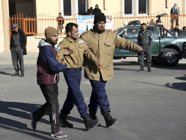 Afghan security personnel escort a man rescued from the Intercontinental Hotel after an attack in Kabul, Afghanistan, Sunday, Jan. 21, 2018. Gunmen stormed the hotel and sett off a 12-hour gun battle with security forces that continued into Sunday morning, as frantic guests tried to escape from fourth and fifth-floor …