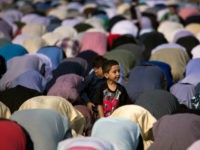 NEW YORK, NY - JUNE 25: A young boy looks on as Muslims participate in a group prayer service during Eid al-Fitr, which marks the end of the Muslim holy month of Ramadan, in Bensonhurst Park in the Brooklyn borough June 25, 2017 in New York City. Muslims around the …