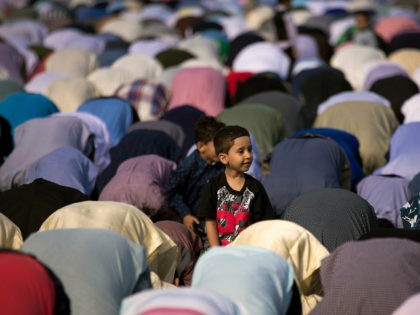 NEW YORK, NY - JUNE 25: A young boy looks on as Muslims participate in a group prayer serv