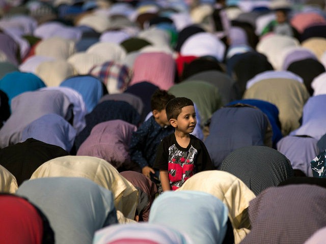 NEW YORK, NY - JUNE 25: A young boy looks on as Muslims participate in a group prayer serv