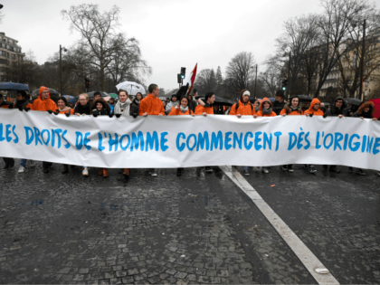 Pro-life demonstrators hold banners reading 'Human rights begin from the origin' in Paris on January 21, 2018 during a 'March for life' demonstration against abortion and medically assisted procreation. / AFP PHOTO / Eric FEFERBERG (Photo credit should read ERIC FEFERBERG/AFP/Getty Images)