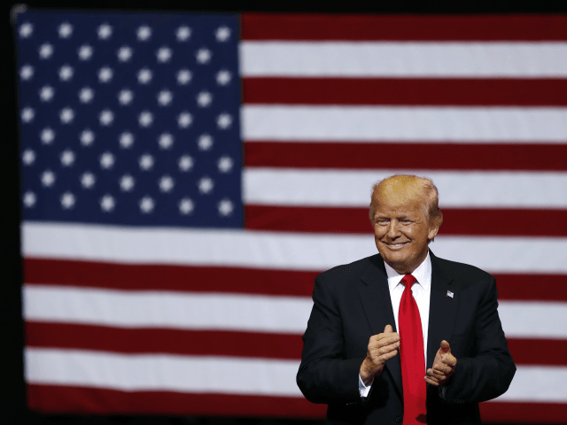 President Donald Trump smiles at supporters as he arrives to speak at a rally, Wednesday,