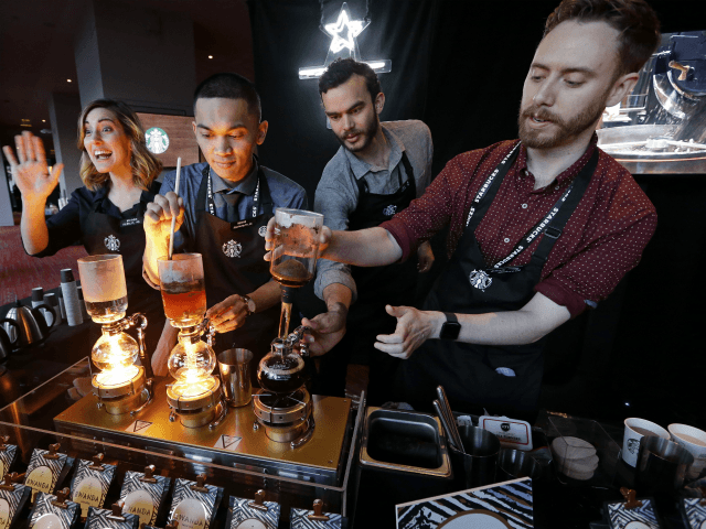 In this Wednesday, March 22, 2017, file photo, baristas from Starbucks' specialized coffee shop, Reserve Roastery, demonstrate a siphon brew of individual cups of coffee before the company's annual shareholder meeting in Seattle. Starbucks is giving its U.S. workers pay raises and stock bonuses in 2018, citing recent tax reform. …