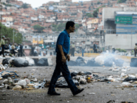 trash in caracas streets A man crosses a street blocked with garbage bags during a protest against Maduro in Caracas, on May 2, 2017. Armed "collectives" pressure low income urban dwellers from joining the protest movement, forcing them to share the view of the ruling Socialists United Party that the political opposition is orchestrating …