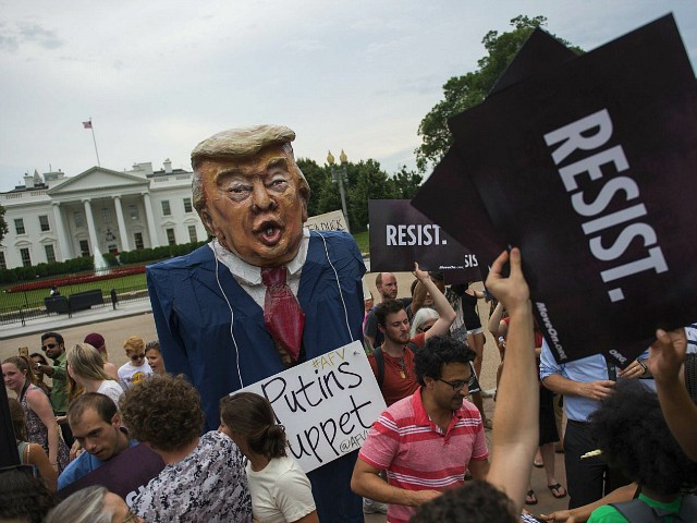 TOPSHOT - Protesters hold up signs near a US President Donald Trump puppet during a rally calling for accountability for the Trump campaign's alleged collusion with the Russian Government in front of the White House in Washington, DC on July 11, 2017. / AFP PHOTO / ANDREW CABALLERO-REYNOLDS (Photo credit should read ANDREW CABALLERO-REYNOLDS/AFP/Getty Images)