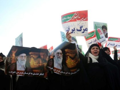 Women hold posters of Iran's supreme leader Ayatollah Ali Khamenei during a pro-regime rally in second city Mashhad on January 4