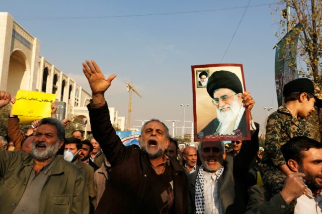 A man holds a poster of Iran's supreme leader Ayatollah Ali Khamenei and revolutionary founder Ayatollah Ruhollah Khomeini during a pro-government march in Tehran on January 5, 2018