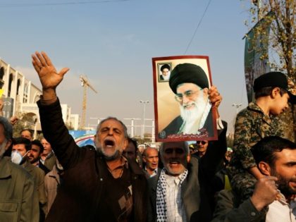 A man holds a poster of Iran's supreme leader Ayatollah Ali Khamenei and revolutionary founder Ayatollah Ruhollah Khomeini during a pro-government march in Tehran on January 5, 2018