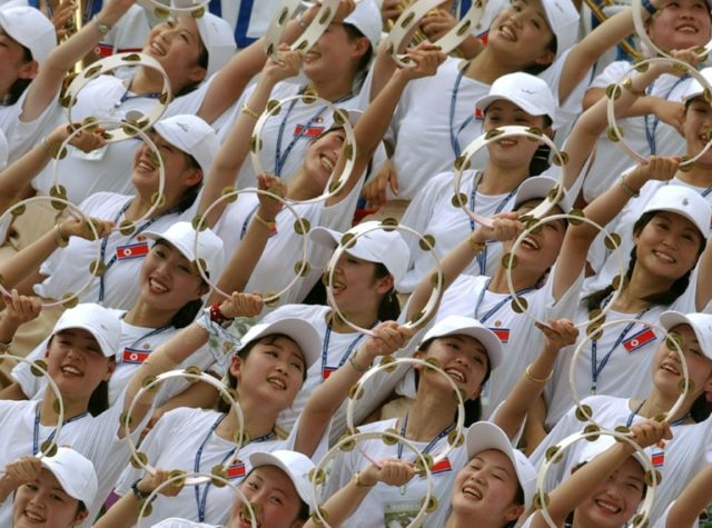 North Korean cheerleaders make a wave during their team's women's football match