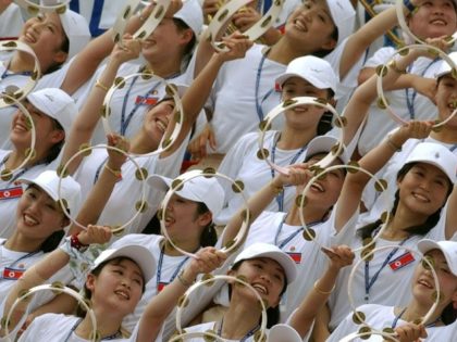 North Korean cheerleaders make a wave during their team's women's football match