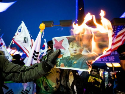 PYEONGCHANG, SOUTH KOREA - FEBRUARY 9, 2018: People burn a portrait of Kim Jong-un in protest against North Korean athletes' participation in the 2018 Winter Olympic Games outside the Pyeongchang Olympic Stadium ahead of the opening ceremony in Pyeongchang, South Korea. Sergei Bobylev/TASS (Photo by Sergei Bobylev\TASS via Getty Images)