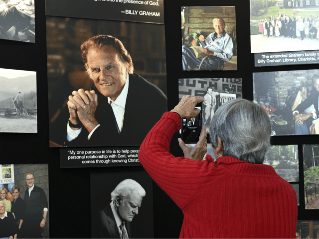 Lyn Warwick of Black Mountain, N.C., photographs a memorial display of Rev. Billy Graham i