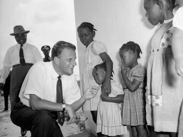 Evangelist Billy Graham meets children during a visit to a missionary institute Jan. 20, 1