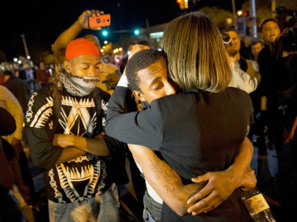 State Sen. Catherine E. Pugh, right, D-Baltimore, embraces a protestor while urging the crowd to disperse ahead of a 10 p.m. curfew in the wake of Monday's riots following the funeral for Freddie Gray, Tuesday, April 28, 2015, in Baltimore. (AP Photo/David Goldman)