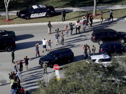 Students being led from are brought out of the Marjory Stoneman Douglas High School following shooting that killed 17 students. AP Photo: Mike Stocker
