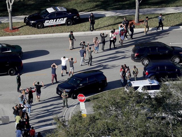Students being led from are brought out of the Marjory Stoneman Douglas High School follow