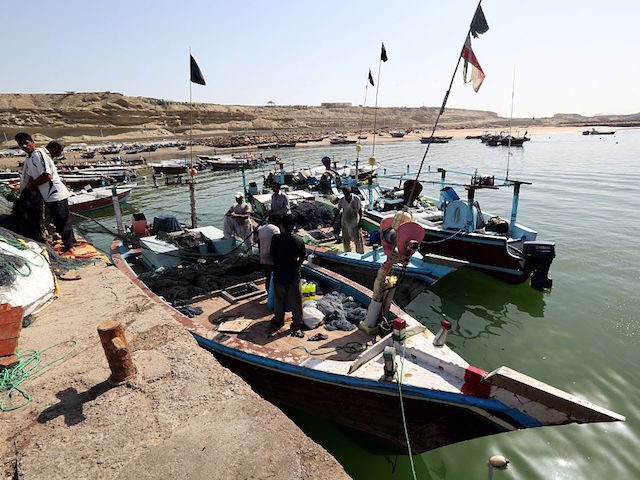 Iranian fishermen clean their nets after unloading their catch in the southern port city o