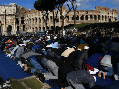 Muslim men attend Friday prayers near Rome's ancient Colosseum on October 21, 2016 to