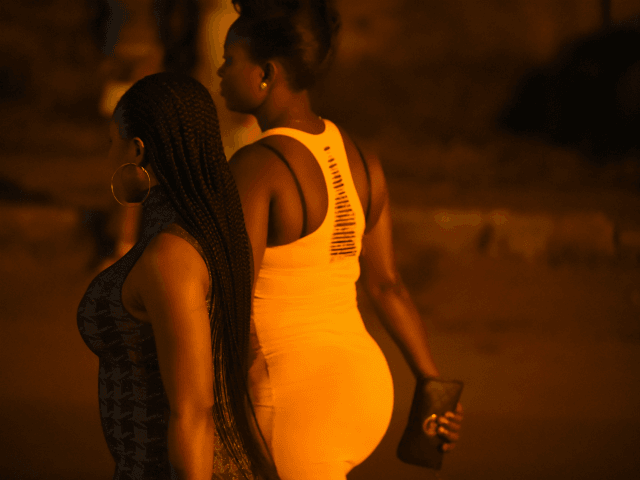 Prostitutes stand walk on the street in Benin City, capital of Edo State, southern Nigeria, on March 29, 2017. In Benin City, Nigeria's capital of illegal migration, no one says the word 'prostitution'. The word on the street for the young girls who leave for Italy or France is 'hustling'. …