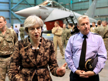British Prime Minister Theresa May (L) speaks with troops upon her arrival to wish British servicemen happy holidays, at the RAF Akrotiri British military base, in the British Overseas Territory, on the east Mediterranean island of Cyprus on December 21, 2017. / AFP PHOTO / POOL / Petros Karadjias (Photo …