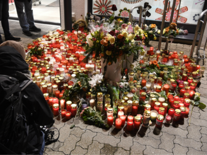 People leave candles and flowers outside a grocery store where a 15-year-old girl was stab