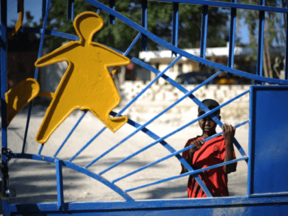 A child waits at the gates of the SOS Children's Village in Croix des Bouquets, outside of Port-au-Prince on February 1, 2010. Ten members of a US Christian group charged with child-trafficking in Haiti could be tried in the United States and will possibly go before a judge later today, …