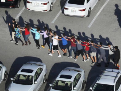 People are brought out of the Marjory Stoneman Douglas High School after a shooting at the