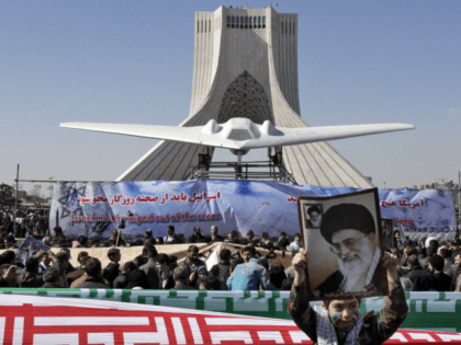 A model of a U.S. RQ-170 Sentinel, captured by Iran in December near the border with Afghanistan, is displayed in front of the Azadi (freedom) tower, as a boy holds a poster showing supreme leader Ayatollah Ali Khamenei, at a rally marking the 33rd anniversary of the Islamic Revolution that …