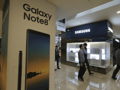 People pass by an advertisement of Samsung Electronics' Galaxy Note 8 smartphone at its shop in Seoul, South Korea, Wednesday, Jan. 31, 2018. Samsung Electronics has reported a surge in quarterly earnings thanks to its record-breaking chip business. (AP Photo/Ahn Young-joon)