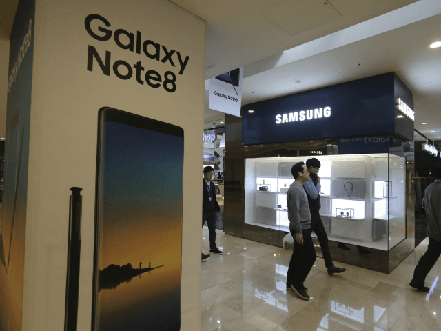 People pass by an advertisement of Samsung Electronics' Galaxy Note 8 smartphone at its sh