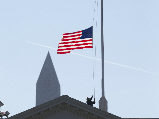 A worker lowers the U.S. flag above the White House in Washington, Monday, March 7, 2016.