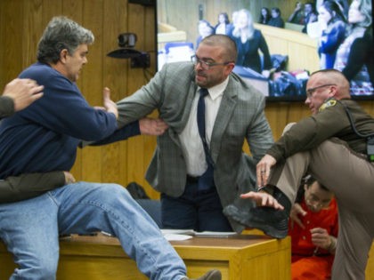 Randall Margraves, father of three victims of Larry Nassar , left, lunges at Nassar, bottom right, Friday, Feb. 2, 2018, in Eaton County Circuit Court in Charlotte, Mich. The incident came during the third and final sentencing hearing for Nassar on sexual abuse charges. The charges in this case focus …