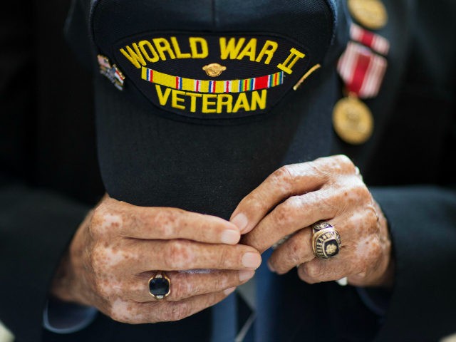 World War II veteran Stanley Byars, 92, of Atlanta, center, holds his hat during the singi