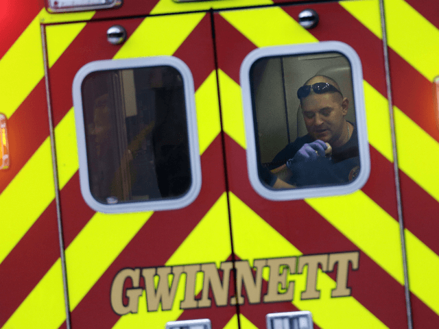 An EMT works in the back of an ambulance as it leaves an Suwanee, Ga., subdivision after a