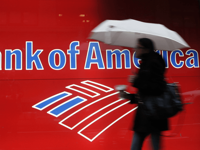 In this Dec. 7, 2011 photo, a woman passes a Bank of America office branch, in New York. B