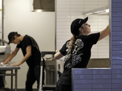 Workers clean inside a still-closed Chipotle restaurant Monday, Nov. 9, 2015, in Seattle.