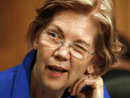 Sen. Elizabeth Warren, D-Mass., winks as she jokes with other senators on the Senate Banki