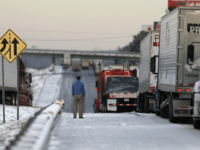 freeway accident A man stands on the frozen roadway as he waits for traffic to clear along Interstate 75 Wednesday, Jan. 29, 2014, in Macon, Ga. A winter storm dumped snow and covered parts of the state with ice. Gov. Nathan Deal said early Wednesday that the National Guard was sending military …