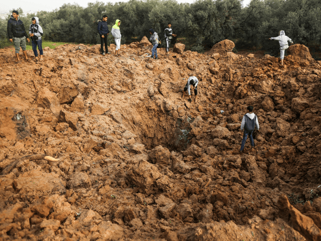 Palestinians check the site of an Israeli air strike in Gaza City on February 18, 2018. Tw