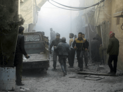 This photo released on Saturday, Feb 24, 2018 by the Syrian Civil Defense group known as the White Helmets, shows members of the Syrian Civil Defense group and civilians gathering to help survivors from a street attacked by airstrikes and shelling by Syrian government forces, in Ghouta, a suburb of …