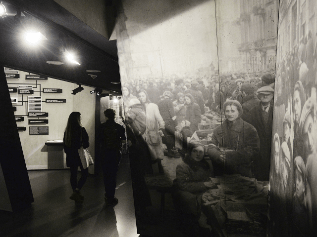 Visitors to the POLIN Museum of the History of Polish Jews look at exhibits from the Warsa
