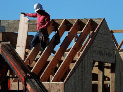 A worker stands on the roof of a home under construction at a new housing development in San Rafael, California.