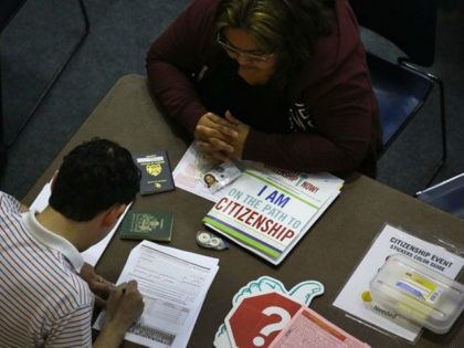 An immigrant (R), receives assistance with her U.S. citizenship application at a Citizensh