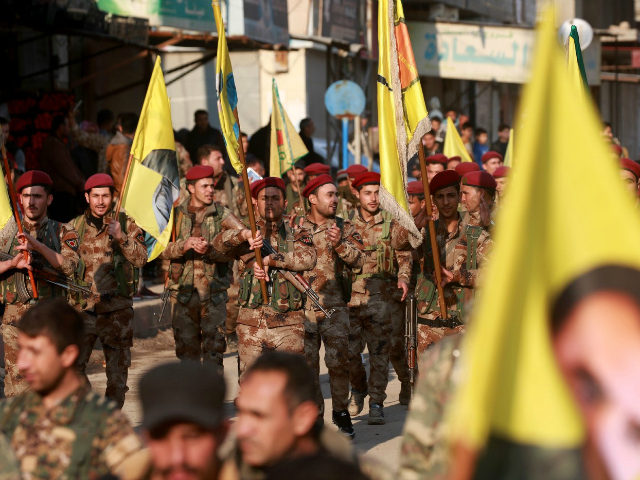 Kurdish People's Protection Units (YPG) military police members demonstrate with their fla