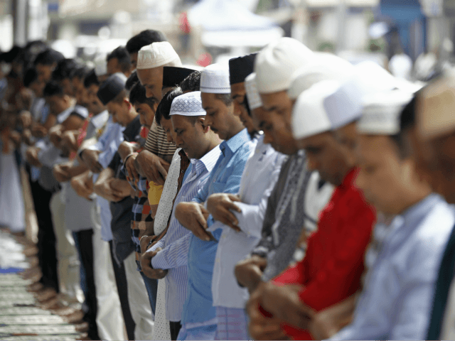 Bangladeshi Muslims living in Malaysia offer a prayer on a street during the first day of