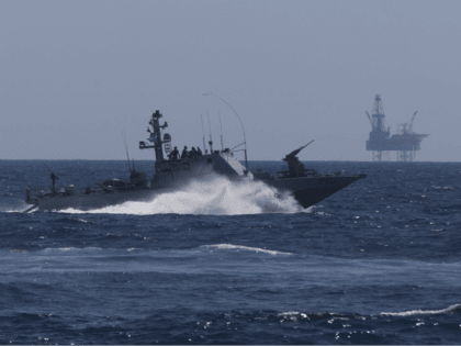 An Israeli Navy vessel passes by the Tamar drilling natural gas production platform during