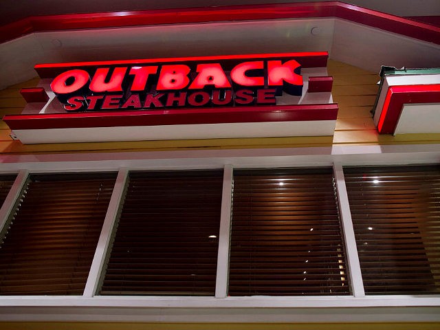 Outback Steakhouse signage is displayed outside of a restaurant location at the Queens Pla
