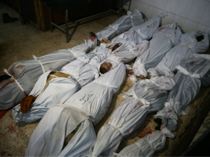 The bodies of civilians who were killed in Syrian army bombardment on the town of Hamouria in the rebel-held enclave of Eastern Ghouta are seen lying on the ground at a make-shift morgue the morning after the attacks on February 20, 2018. / AFP PHOTO / ABDULMONAM EASSA (Photo credit …