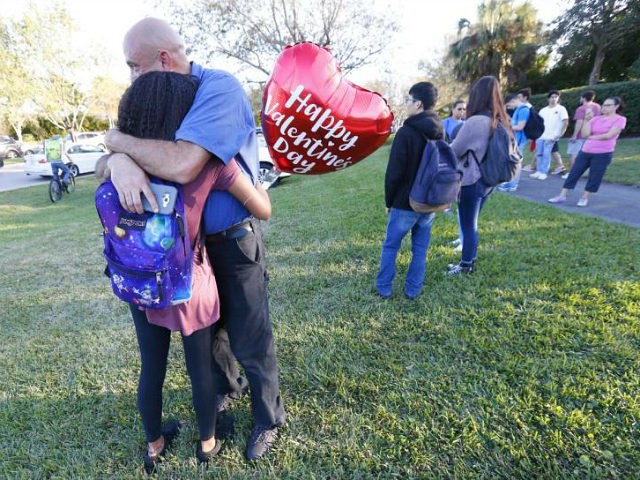 Family member embrace following a shooting at Marjory Stoneman Douglas High School, Wednes